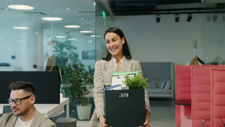 Trabajadora sonriendo con una caja de material de oficina